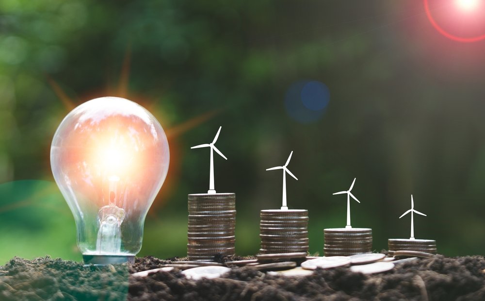 Lightbulb,And,Stacks,Of,Coins,On,Soil,With,Windmill,Icon,